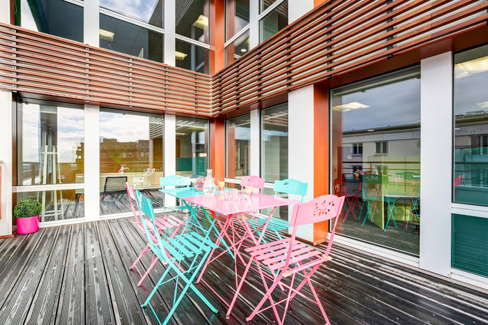 terrasse en bois pour bureau avec chaises et table de couleur